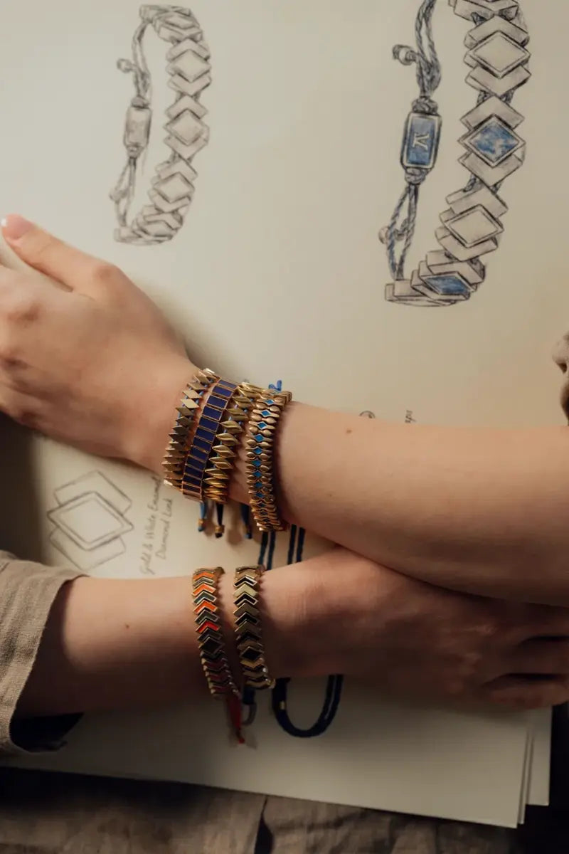 Guillos tejidos a mano en la muñeca, junto a bocetos de diseño