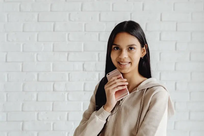 Mujer sonriente con su teléfono en la mano